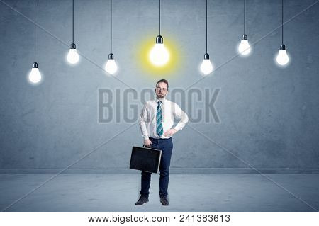 Handsome businessman in an empty space with bulbs above and uninspired face