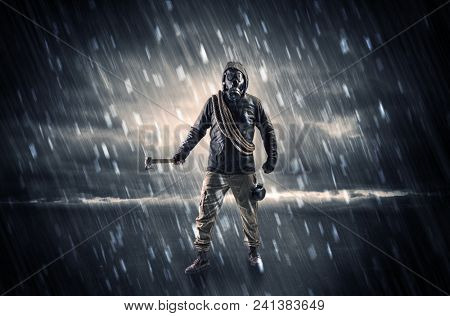 Terrorist in a stormy space with gas mask on his hand and weapons on his arm