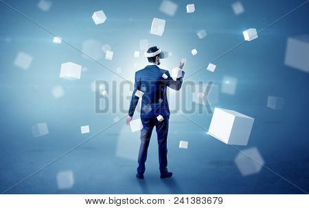 Handsome businessman with vr goggle and falling white cubes around