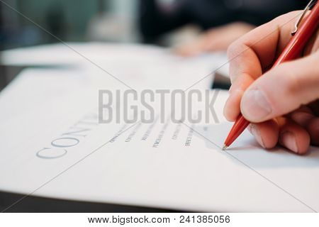 Man Hand Signing Contract Closeup. Business Partnership And Cooperation. Deal Closing And Legal Docu