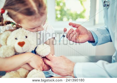 Doctor Pediatrician Injecting Vaccine To Cute  Girl