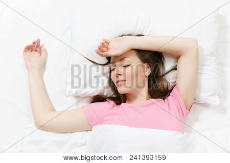 Top View Of Head Of Happy Brunette Young Woman Lying In Bed With White Sheet, Pillow, Blanket. Sleep