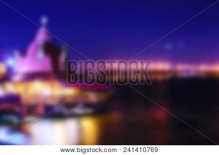 Beautiful Blurred Night Dnipro City View. Dark Bue Sky, River And Building With Lights Or Illuminati