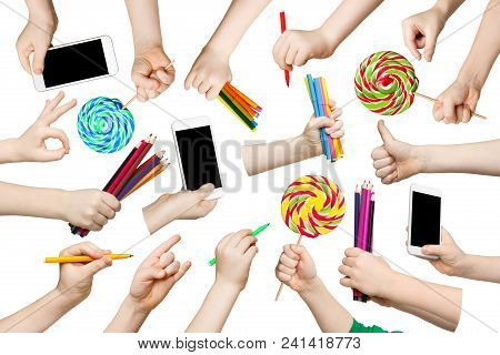 Set Of Child Hands Holding Items. Gadgets, Lollipops, Pencils In Various Hadns. Isolated At White Ba