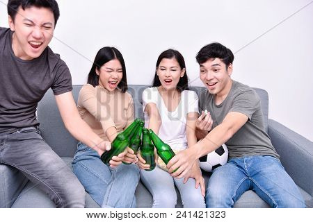 Concept Of Cheering. Asian Teenagers Watching Football On Television. People Are Cheering And Winnin