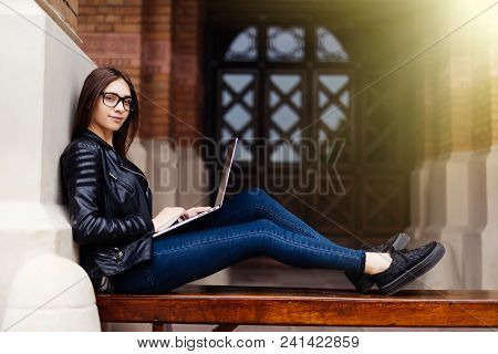 Young Female Blogger Chatting With Followers And Sending Feedbacks Resting On Bench In Town With Net