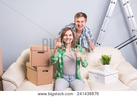 Young Married Couple With Boxes And Holding Flat Keys