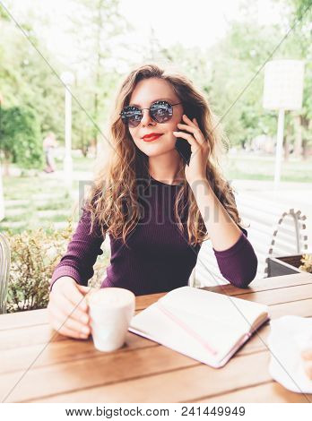 Beautifl Attractive Young Blonde Woman With Curly Hair Drinking Cappuccino And Talking On Telephone 