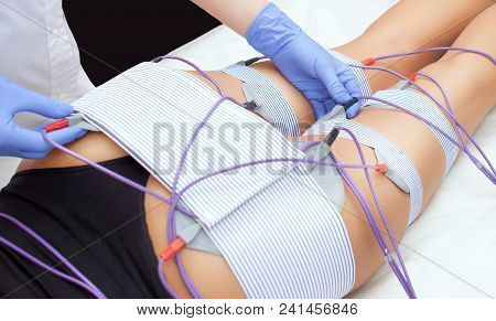 The Procedure Of Myostimulation On The Legs And Buttocks Of A Woman In A Beauty Salon. Caring For Th