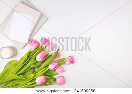 Minimal Styled Flat Lay With Pink Tulips Flowers With Petals And White Envelope, Notebooks And Candl