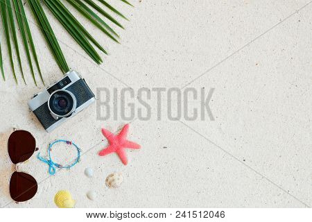 Beach Background.  Top View Of Beach Sand With Coconut Leaves, Camera, Bracelet Made Of Seashells, S