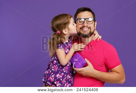 Happy Father's Day! Cute Dad And Daughter Hugging On Violet Background.