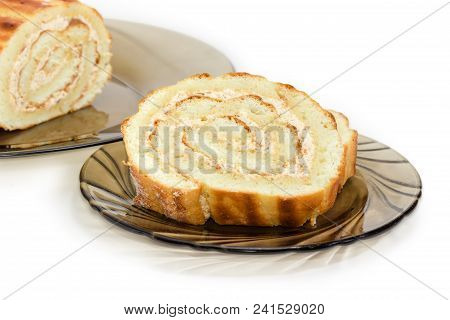 Partly Sliced Swiss Roll Filled With Buttercream And Jam On The Dark Glass Dishes Closeup At Selecti
