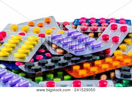 Pile Of Tablet Pills Isolated On White Background. Yellow, Purple, Black, Orange,  Pink , Green Tabl