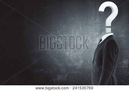 Question Headed Businessman Standing On Concrete Wall Background With Copy Space. Enquiry Concept