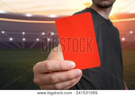 Referee Is Showing Red Card As A Penalty For A Foul In Soccer Stadium.