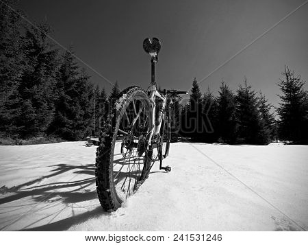 Mountain Bike Standing In Frozen Snow Against Blue Sky. Hidden  Asphalt Road Under Sow Cover. Extrem
