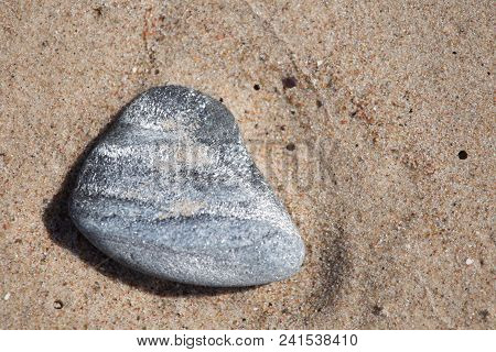 Beautiful Smooth Sea Stones In The Sands Of The Beach. Closeup Photo Of Stone Textures And Shapes.