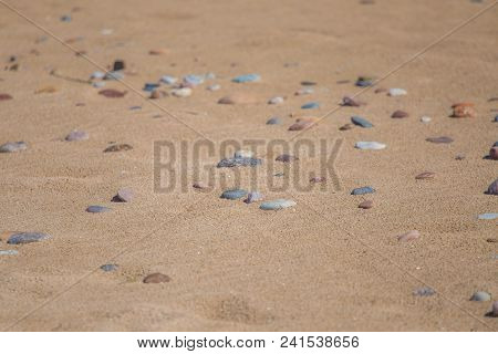 Beautiful Smooth Sea Stones In The Sands Of The Beach. Closeup Photo Of Stone Textures And Shapes.