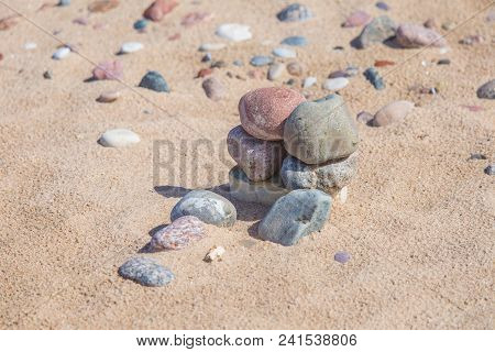 Beautiful Smooth Sea Stones In The Sands Of The Beach. Closeup Photo Of Stone Textures And Shapes.