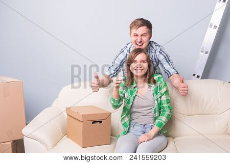 Young Married Couple With Boxes And Holding Flat Keys