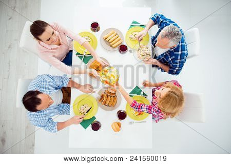 Top View Portrait Of Festive Stylish Attractive Relatives Imposing Food In Plates, Eating With Knife