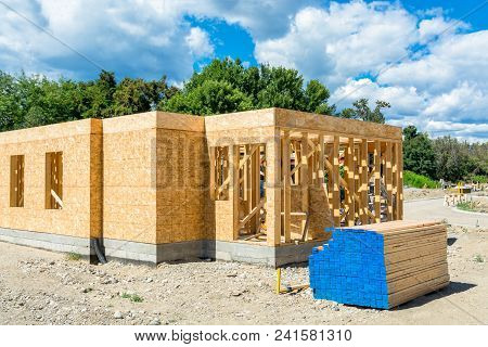 Wooden Frame Of New Building With Engineered Lumber Materials On Site Prepared For Construction. Tow