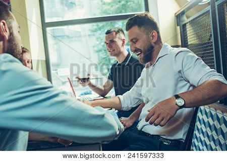 Young Cheerful People Smile And Gesture While Relaxing In Pub. Team Job. Photo Young And Mature Busi