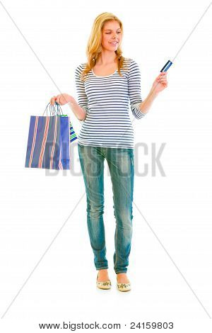 Full Length ritratto di attraente ragazza Teen con shoppers e carta di credito