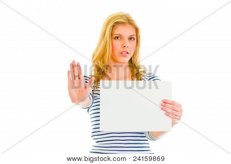 Bella ragazza Teen tenendo il foglio di carta bianca e mostrando il gesto di Stop