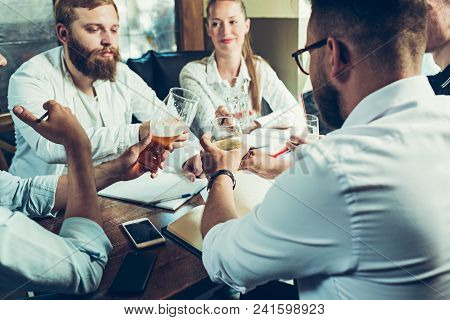 Young Cheerful People Smile And Gesture While Relaxing In Pub. Team Job. Photo Young And Mature Busi