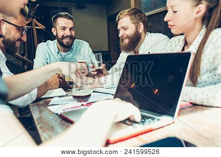 Young Cheerful People Smile And Gesture While Relaxing In Pub. Team Job. Photo Young And Mature Busi