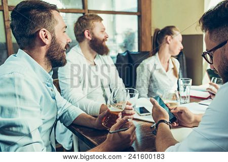 Young Cheerful People Smile And Gesture While Relaxing In Pub. Team Job. Photo Young And Mature Busi