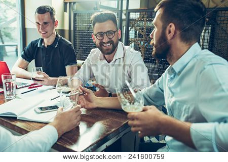 Young Cheerful People Smile And Gesture While Relaxing In Pub. Team Job. Photo Young And Mature Busi