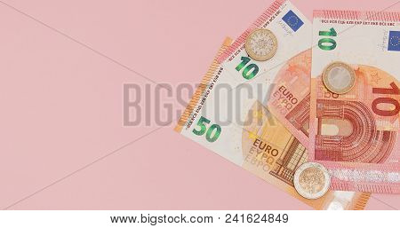 Euro Money: Closeup Of Banknotes And Coins On A Pink Background. Business Concept.