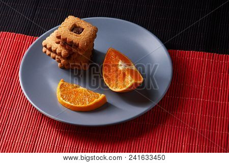 Chocolate Chip Cookies And Orange On Gray Plate And On Red With Black Table