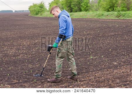 Man To Seek Treasure On Earth With A Metal Detector, Walks The Field, Squeak Gold