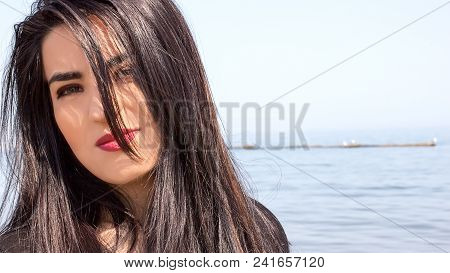 Happy Woman On The Beach. Portrait Of A Beautiful Girl Close-up. Spring Portrait On The Beach. Young