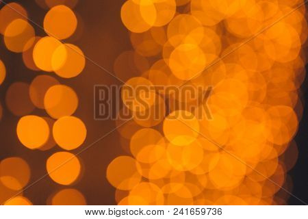 Many Blurred Small Electric Bulbs On A Wall. Yellow Blurred Lights. Wall Of Christmas Lights