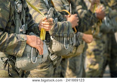 Row Of Police Paratrooper In Camouflage Uniform Hold T-10 Static Line Hook And Parachute Reserve In 