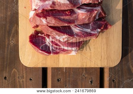 Overhead View Of Raw Cuting Pieces Of Pork On Wooden Background. Piece Of Fresh Boneless Pork, Neck 