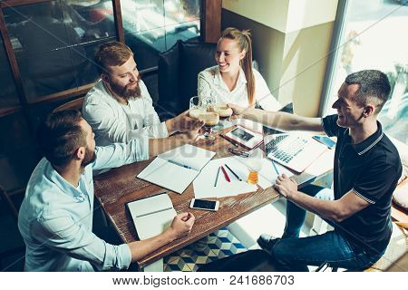 Young Cheerful People Smile And Gesture While Relaxing In Pub. Team Job. Photo Young And Mature Busi