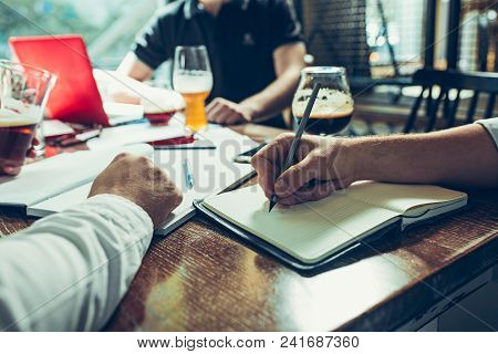 Young Cheerful People Smile And Gesture While Relaxing In Pub. Team Job. Photo Young And Mature Busi