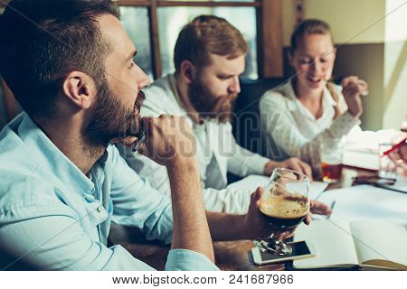 Young Cheerful People Smile And Gesture While Relaxing In Pub. Team Job. Photo Young And Mature Busi