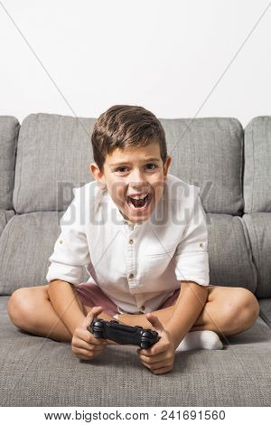 Anxious Boy Playing Console At Home Alone