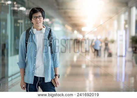 Young Asian Happy Man Dressed In Casual Style Standing With Backpack In The International Airport Te