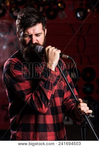 Man With Enthusiastic Face Holds Microphone, Singing Song, Karaoke Club Background. Musician With Be