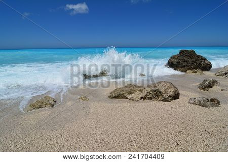 Windy Day On Famous Kathisma Beach, Lefkada, Greece; White Sea Foam Of Crashing Waves Over Stones, P