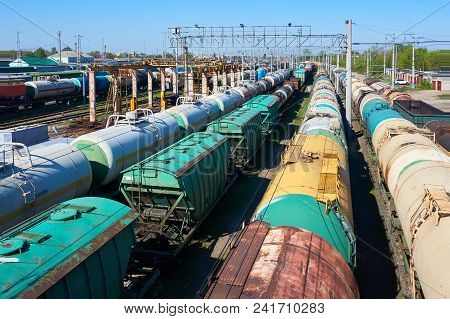 Railway Landscape With Many Old Railway Freight Cars On Rails On A Sunny Day Close Up.
