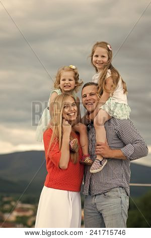 Kids Enyoj Happy Day. Children And Parents Enjoy Vacation Together. Girls Sit On Mother Father Shoul